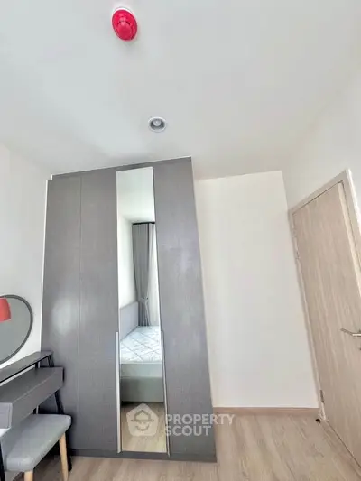 Modern bedroom with sleek wardrobe and stylish desk, perfect for urban living.