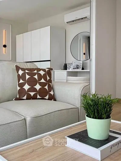 Modern living room with stylish decor, featuring a cozy sofa, chic cushion, and elegant wall art.