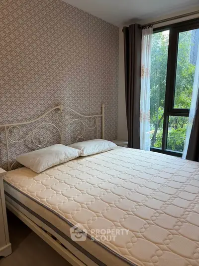 Cozy bedroom with elegant metal bed frame and large window with garden view.