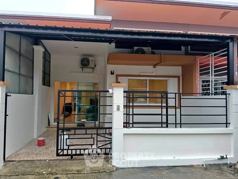 Charming single-story home with modern exterior and gated entrance, perfect for cozy living.