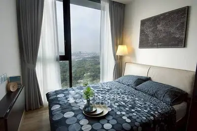 Modern bedroom with large window offering stunning city and park views, stylish decor, and cozy ambiance.