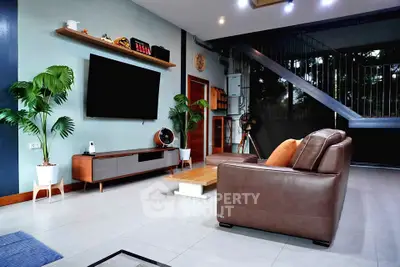 Modern living room with sleek furniture and large TV, perfect for relaxation and entertainment.