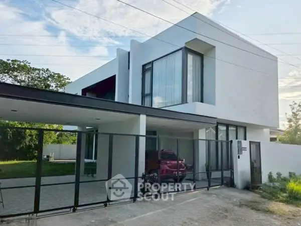 Modern minimalist two-story house with sleek design and spacious carport in a serene neighborhood.