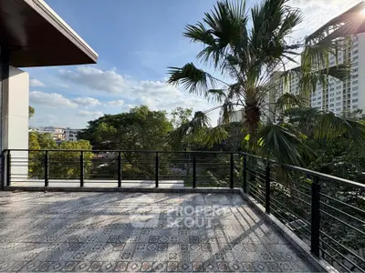 Spacious balcony with scenic view of lush greenery and cityscape, perfect for relaxation.