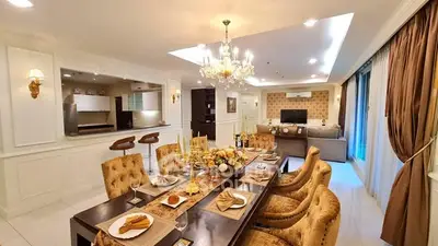 Luxurious open-plan living and dining area with elegant decor and chandelier lighting.