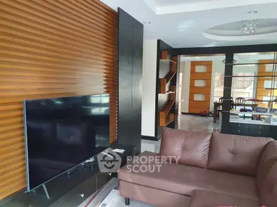 Modern living room with stylish wooden paneling and sleek TV setup