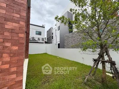 Modern residential building with lush green garden and contemporary design.