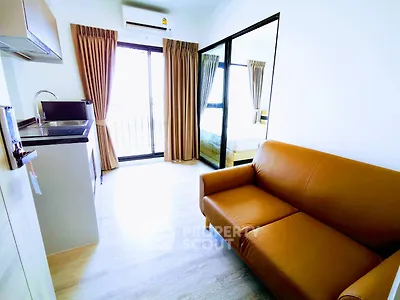 Modern apartment with open layout, featuring a cozy living area and sleek kitchen design.