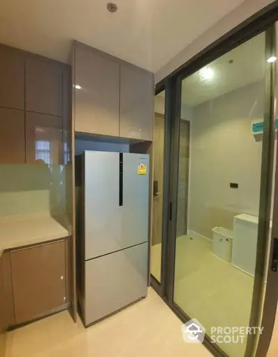 Modern kitchen with sleek fridge and sliding glass door