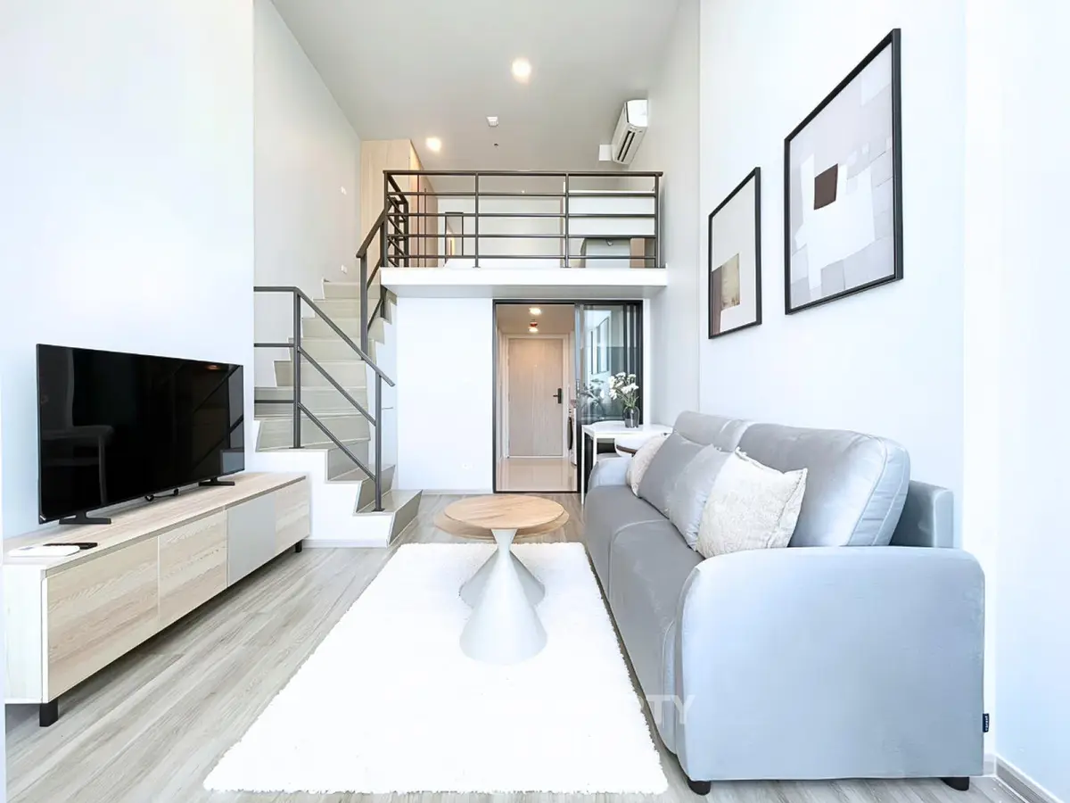 Modern loft-style living room with sleek furniture and high ceilings