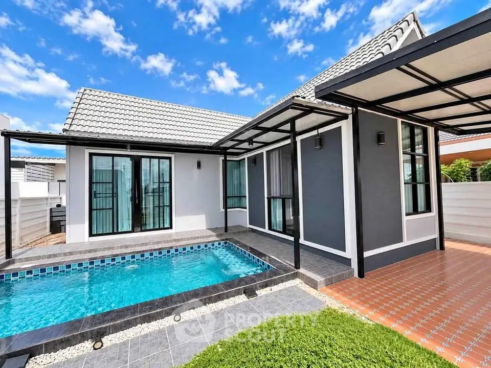 Charming modern house with private pool and stylish exterior design under a clear blue sky.