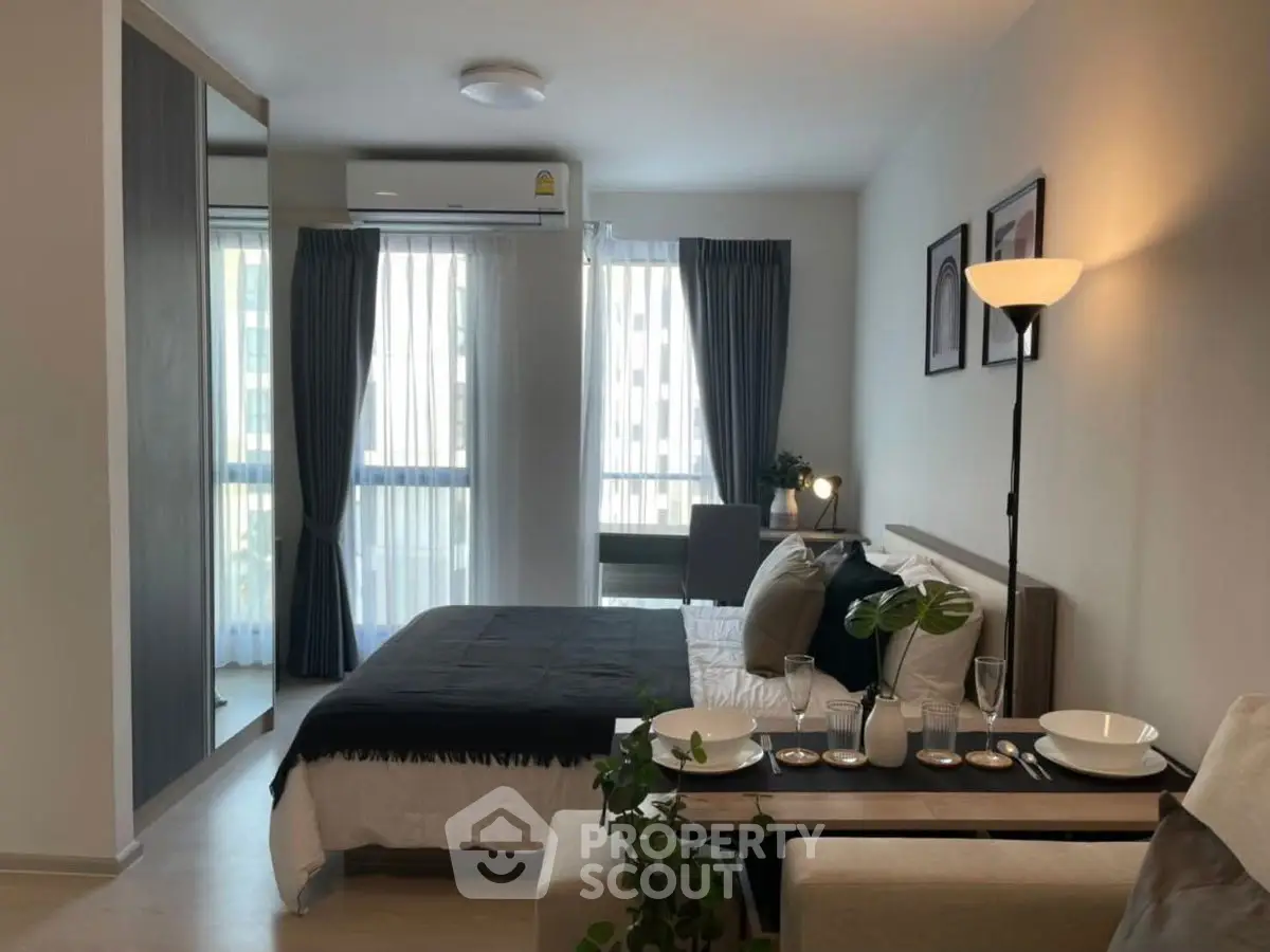 Modern bedroom with stylish decor and natural light in a cozy apartment.