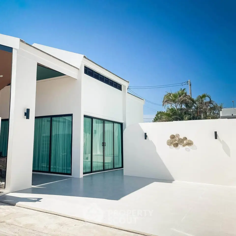 Modern white exterior with large glass doors and minimalist design