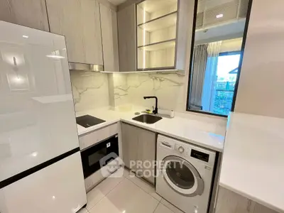 Modern kitchen with sleek appliances and marble backsplash in stylish apartment.