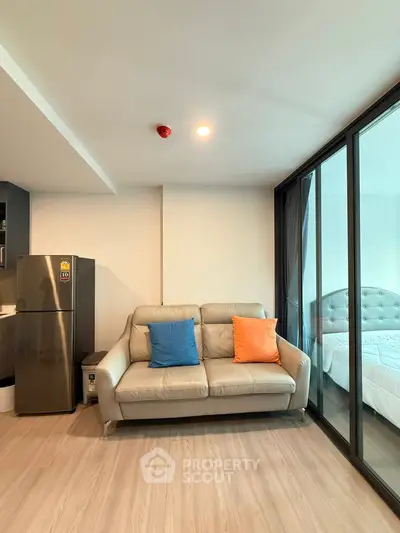 Modern living room with cozy sofa and adjacent bedroom in stylish apartment