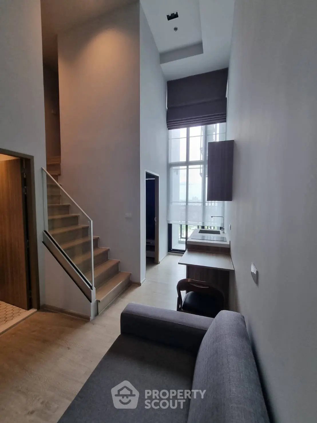 Modern duplex living room with high ceilings and large windows