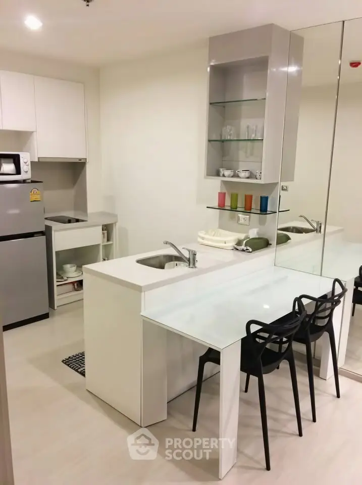 Modern kitchen with sleek design, featuring a compact layout and integrated dining area, perfect for urban living.