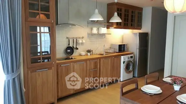 Modern kitchen with wooden cabinets, washing machine, and dining area