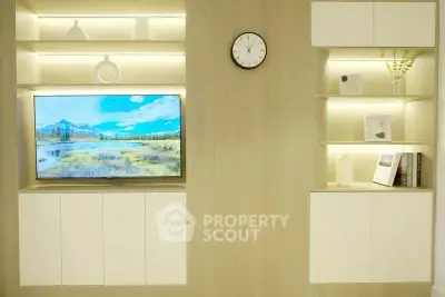 Modern living room with built-in shelves and wall-mounted TV, showcasing minimalist design.