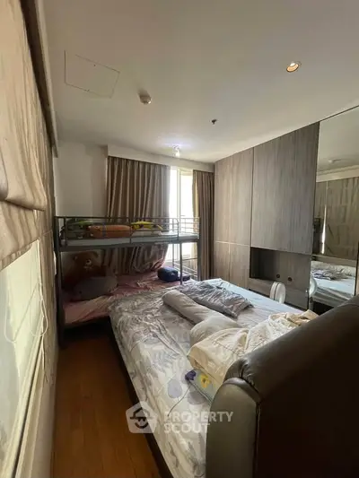 Cozy bedroom with bunk bed and large wardrobe, perfect for family living.
