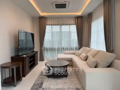 Elegant living room with modern furniture and large TV, perfect for relaxation.