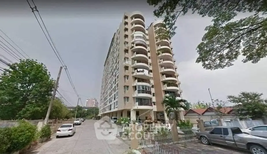 Modern high-rise apartment building with spacious balconies and street view