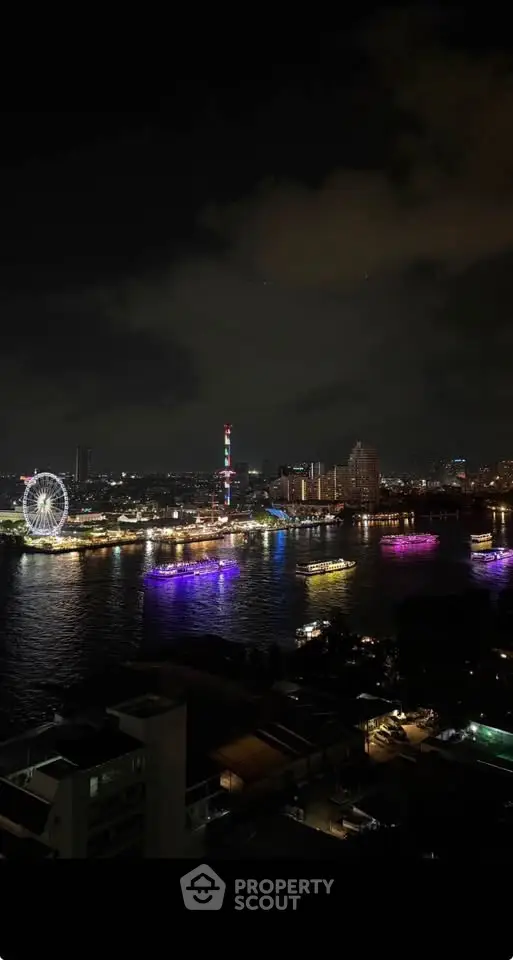 Stunning night view of city skyline with illuminated ferris wheel and river reflections.