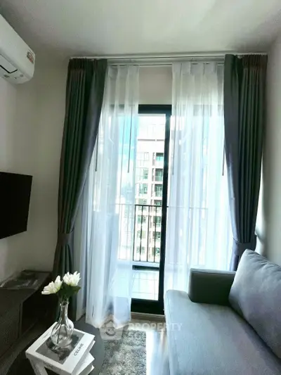 Modern living room with large window and elegant curtains, featuring a cozy sofa and stylish decor.