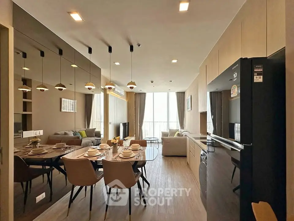 Modern open-plan living room and kitchen with sleek design and ample natural light.