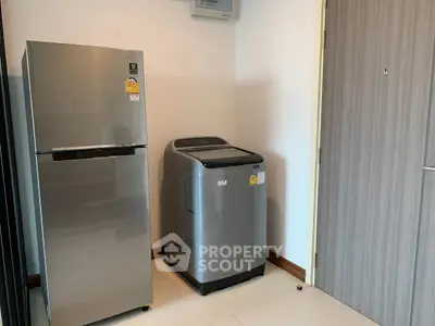 Modern kitchen corner with sleek fridge and washing machine