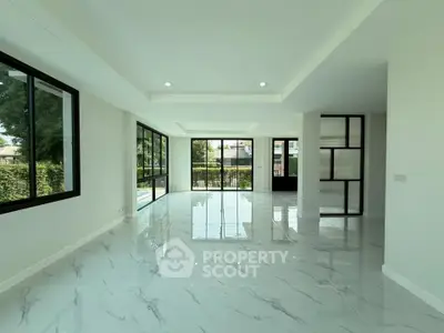 Spacious modern living room with large windows and glossy marble floors