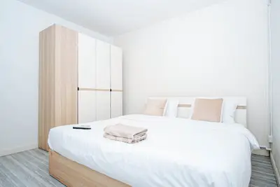 Modern minimalist bedroom with cozy bed and sleek wardrobe design.