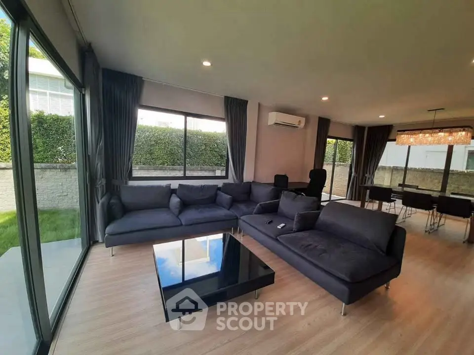 Spacious modern living room with large windows and stylish furniture, perfect for relaxation and entertaining.