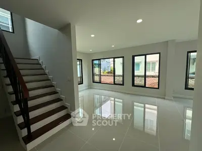 Spacious modern living room with large windows and glossy tiled floors