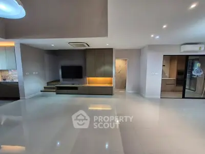 Spacious modern living room with sleek design and built-in entertainment unit.
