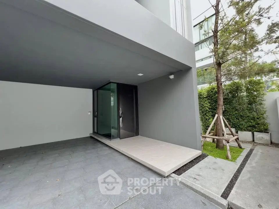 Modern building entrance with sleek design and landscaped garden