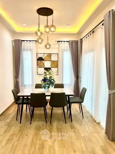 Elegant dining room with modern lighting and stylish decor, featuring a spacious table and chic chairs.
