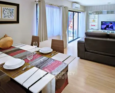 Modern living room with dining area, featuring stylish decor and natural light.