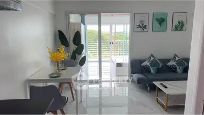 Modern living room with stylish decor and balcony view, featuring sleek furniture and vibrant accents.