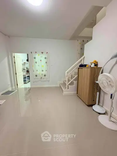 Spacious interior with sleek tile flooring and modern staircase, perfect for contemporary living.