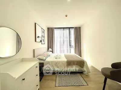 Bright and modern bedroom with stylish decor and large window in a contemporary apartment.