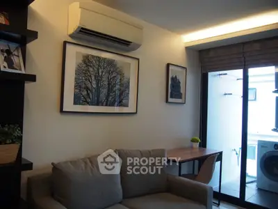 Modern living room with air conditioning and balcony access, featuring stylish decor and a cozy sofa.