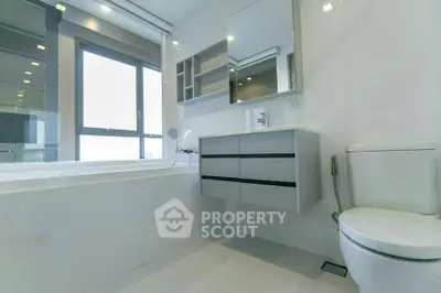 Modern bathroom with sleek fixtures and large window for natural light.