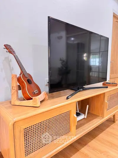 Stylish living room with modern TV setup and wooden cabinet, perfect for cozy entertainment nights.