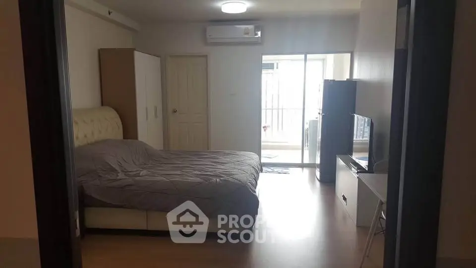 Spacious bedroom with balcony access in modern apartment