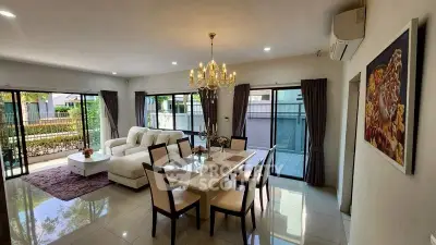 Elegant living and dining area with chandelier and garden view