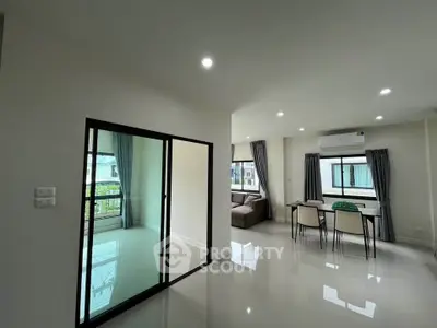 Modern living room with dining area and large windows in a bright apartment
