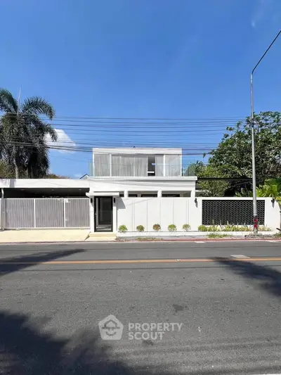 Modern minimalist white house with sleek design and lush greenery