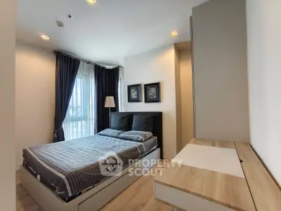 Modern bedroom with stylish decor and large window offering natural light