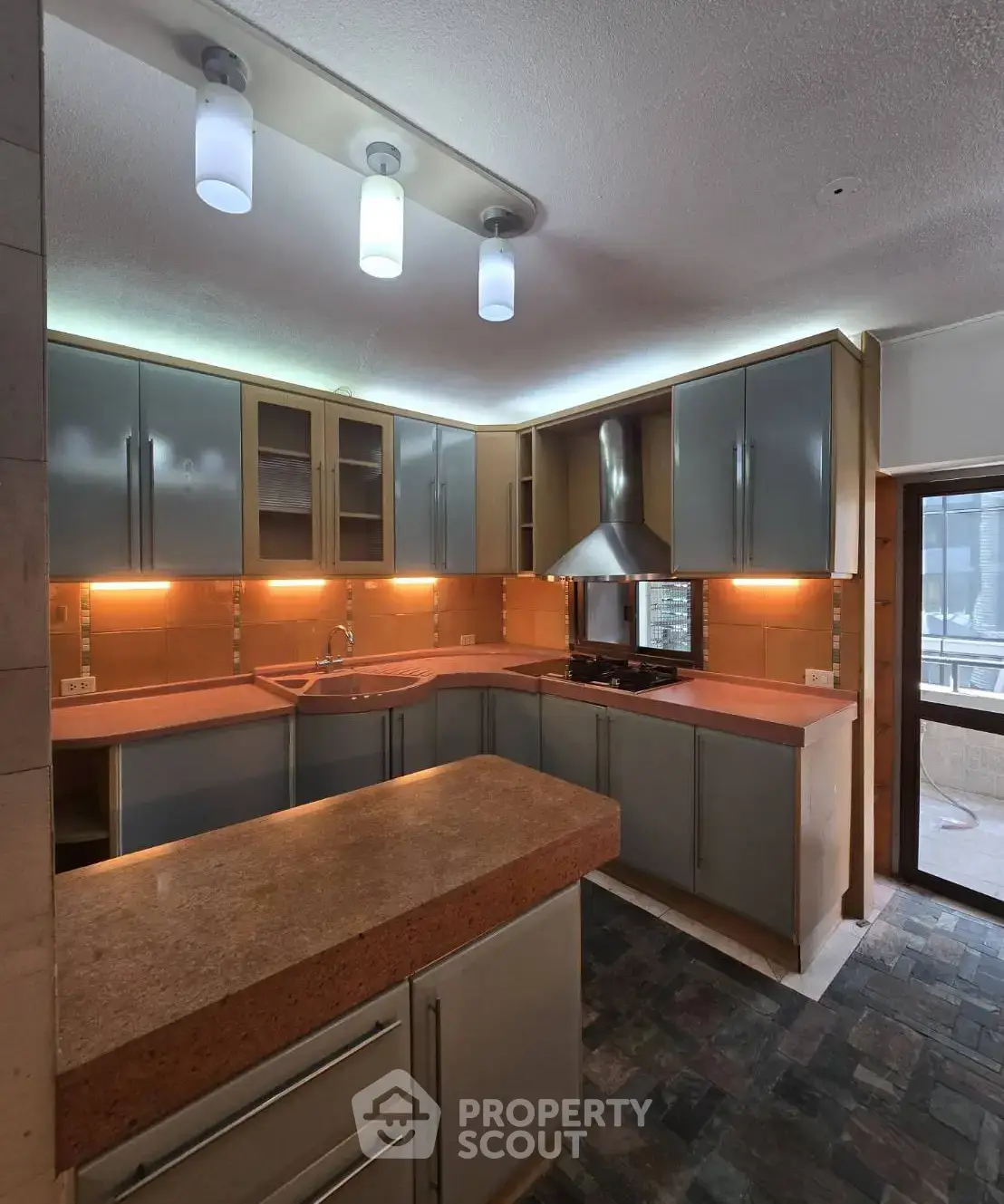 Modern kitchen with sleek cabinetry and ambient lighting, featuring a gas stove and spacious countertops.